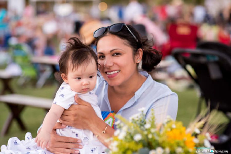 WestFest woman holding baby smiling at camera